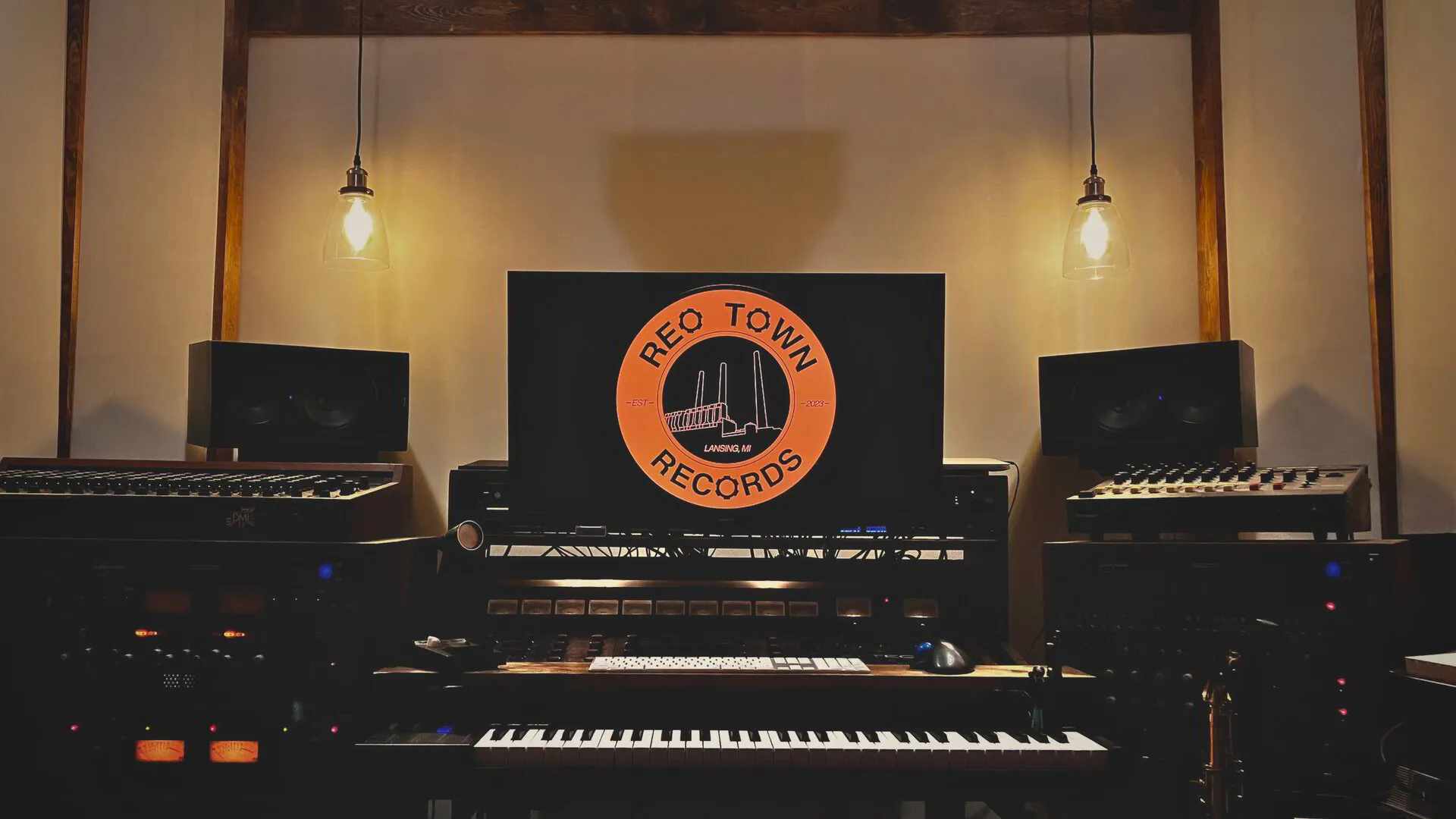 Desktop with a piano keyboard in a recording studio.